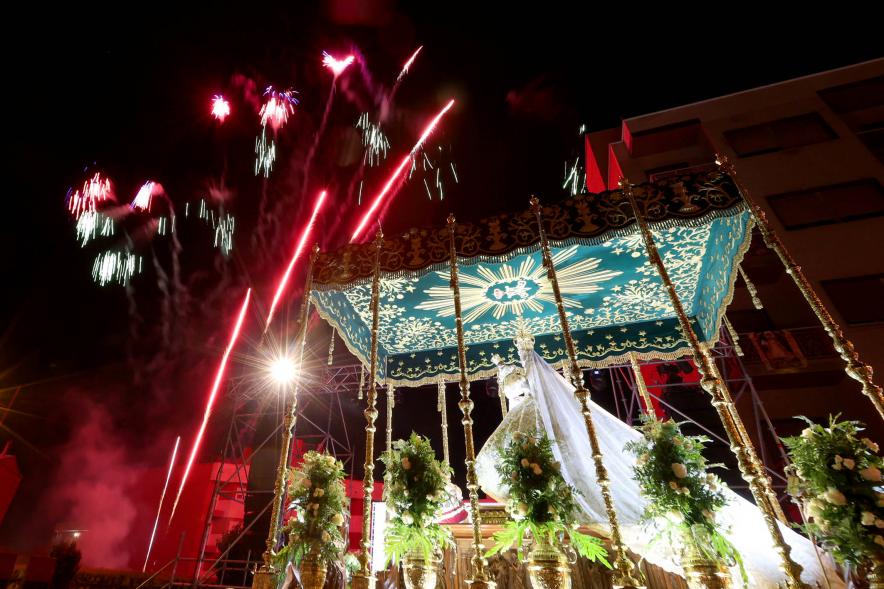Procesión Virgen de la Paz 2023 - Imagen de la Virgen bajo palio, y en el cielo podemos ver fuegos artificiales.