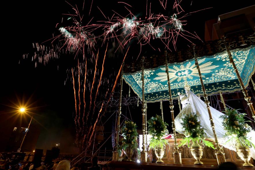 Procesión Virgen de la Paz 2023 - Imagen de la Virgen bajo palio, y en el cielo podemos ver fuegos artificiales.