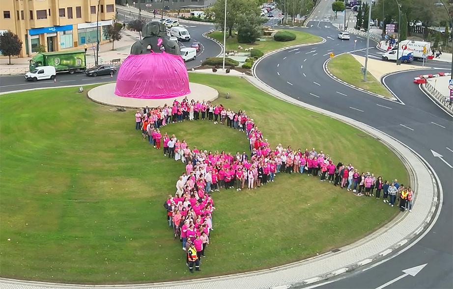Menina con falda rosa y lazo humano con motivo del Día Mundial contra el Cáncer de Mama