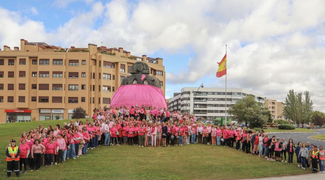 Menina con falda rosa y lazo humano con motivo del Día Mundial contra el Cáncer de Mama