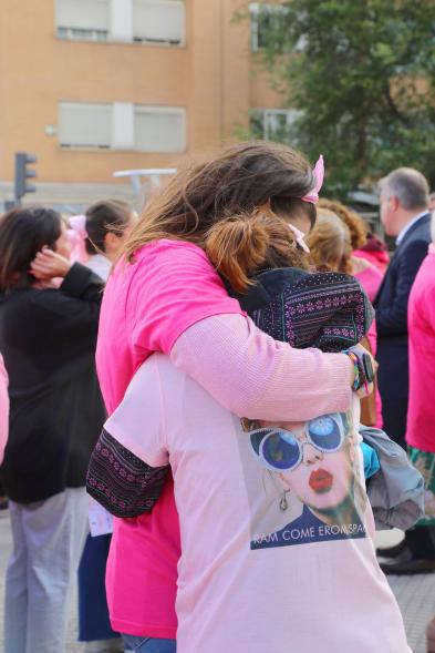 Menina con falda rosa y lazo humano con motivo del Día Mundial contra el Cáncer de Mama