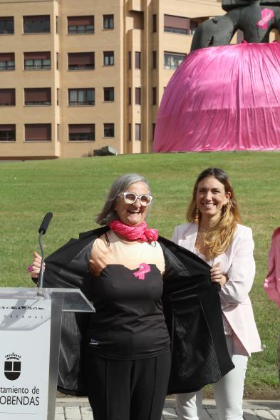 Menina con falda rosa y lazo humano con motivo del Día Mundial contra el Cáncer de Mama