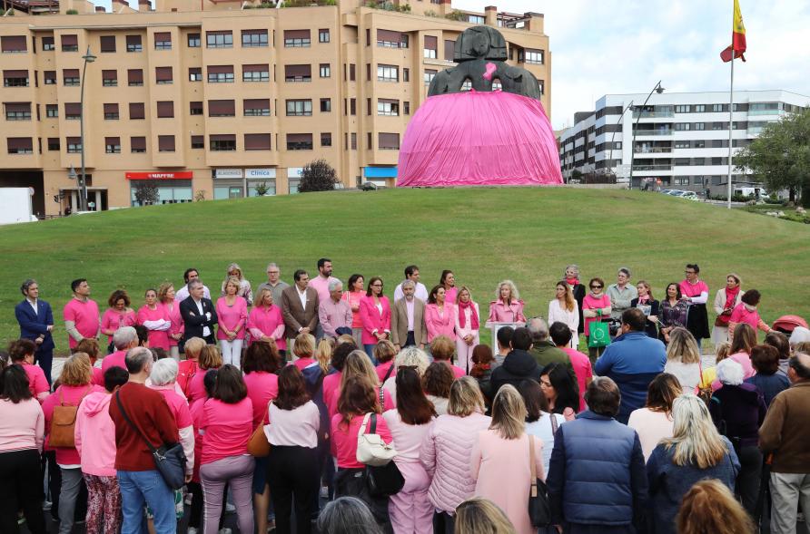 Menina con falda rosa y lazo humano con motivo del Día Mundial contra el Cáncer de Mama