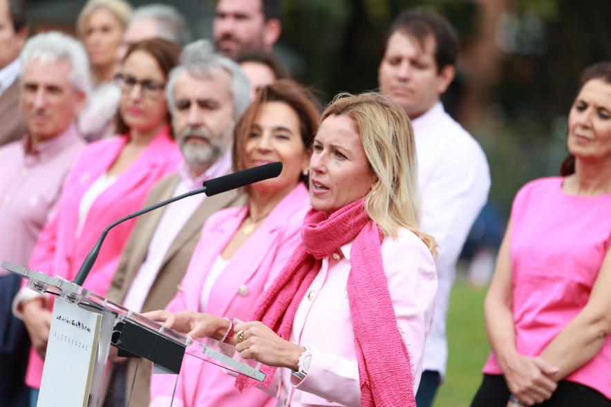 Menina con falda rosa y lazo humano con motivo del Día Mundial contra el Cáncer de Mama