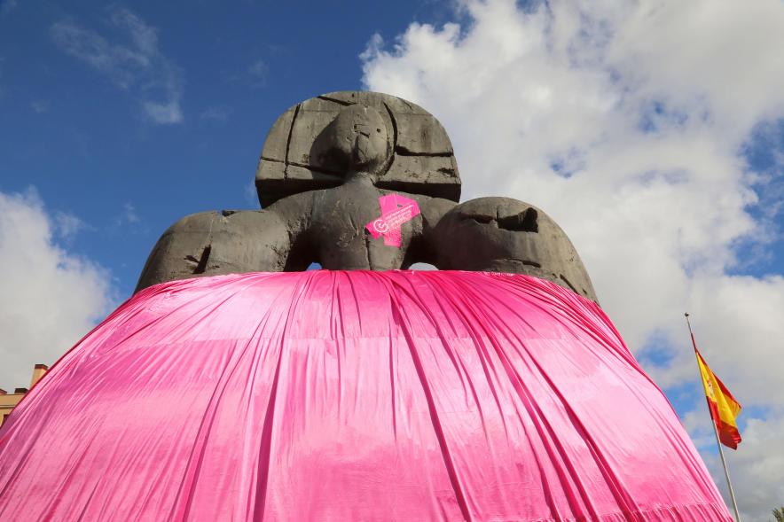 Menina con falda rosa y lazo humano con motivo del Día Mundial contra el Cáncer de Mama