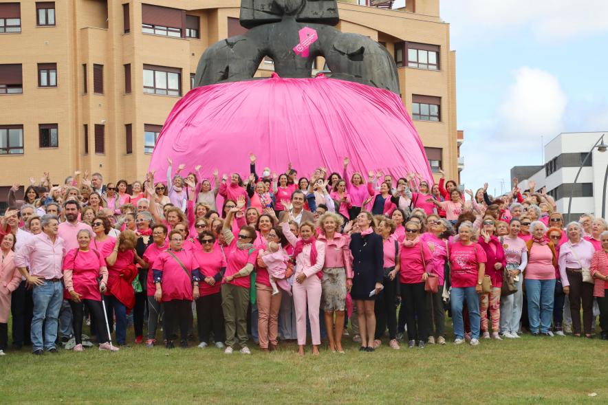 Menina con falda rosa y lazo humano con motivo del Día Mundial contra el Cáncer de Mama