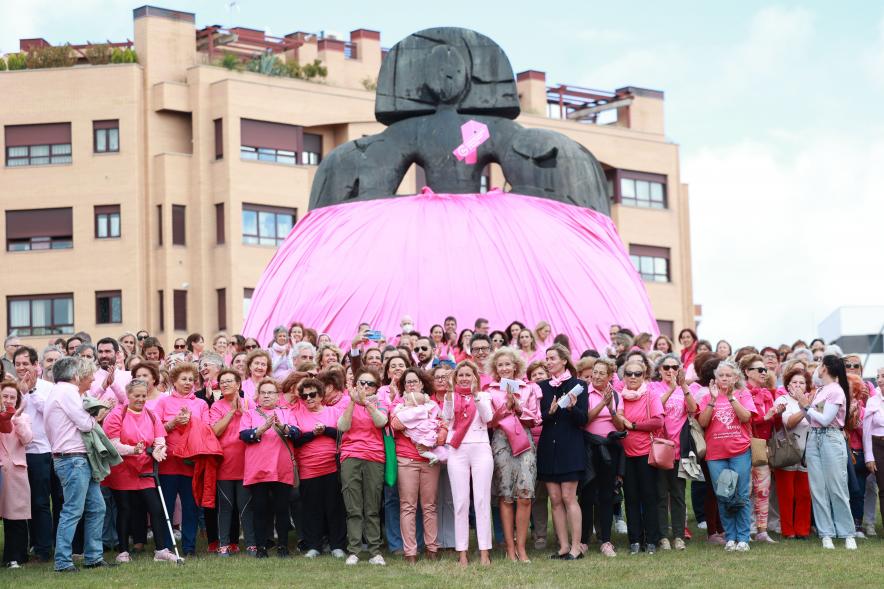 Menina con falda rosa y lazo humano con motivo del Día Mundial contra el Cáncer de Mama