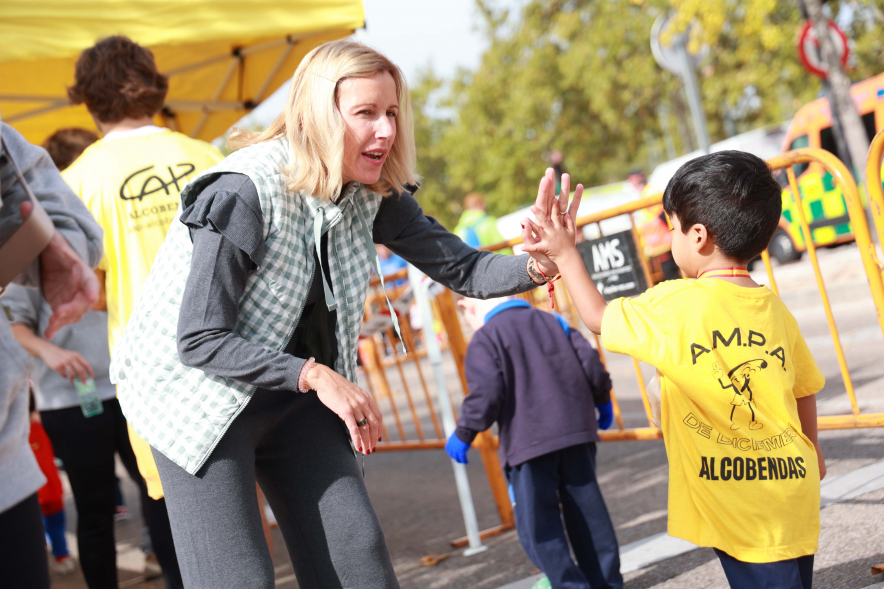 XXXIV Milla Escolar, alcaldesa chocando mano con niño