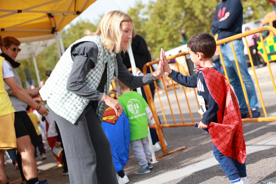 XXXIV Milla Escolar, alcaldesa chocando mano con niño