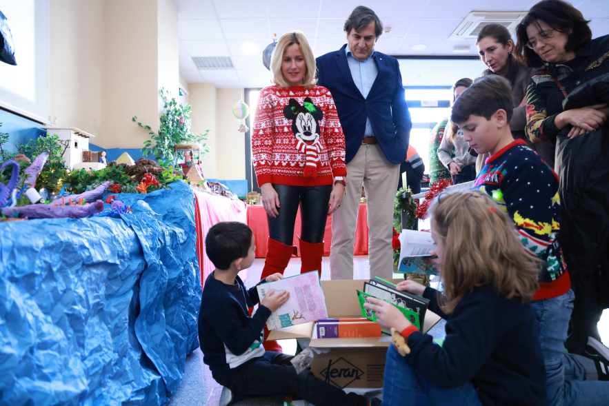 Entrega de premios Concurso de Belenes Escolares, alcaldesa y concejal con niños abriendo el premio