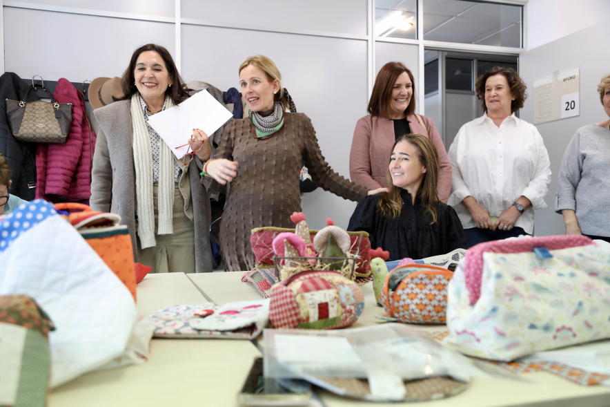 Visita al taller de la Asociación de Artesanas de Alcobendas, alcaldesa y concejal hablando con las mujeres